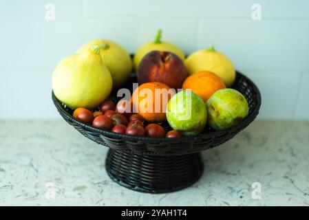 Un cestino di frutta fresca assortita, zucca, pomodori e pesche. Foto Stock