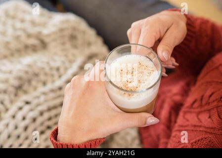 Primo piano di una donna che tiene una tazza di caffè con schiuma Foto Stock