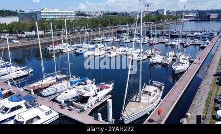 Molte barche a vela a Vauban bassin a le Havre nella soleggiata giornata di maggio. Le persone che attraversano il ponte in lontananza> diverse imbarcazioni hanno un albero più alto. e s Foto Stock