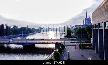 Punto di vista di Wroclaw con il Ponte della Pace (auto e persone) e la Cattedrale di St Giovanni Battista (due torri) e il fiume Oder - soli fantastici Foto Stock