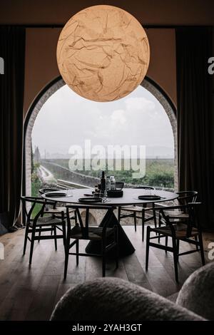 Moderna sala da pranzo con tavolo rotondo e vista panoramica sul vigneto Foto Stock