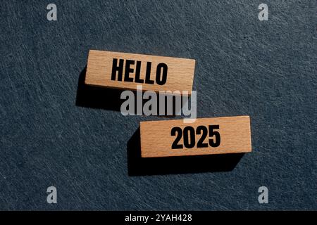 Messaggio Hello 2025 scritto su blocchi di legno con sfondo grigio. Simbolo ciao 2025 concettuale. Copia spazio. Foto Stock