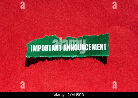 Messaggio di annuncio importante scritto su un foglio di carta verde strappato con sfondo rosso. Simbolo di annuncio concettuale importante. Copia spazio. Foto Stock