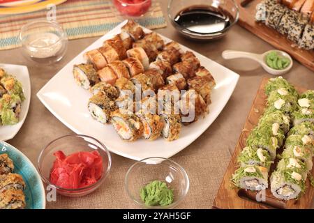 Set di sushi, salsa, wasabi, tè sul tavolo della festa. Cibo e cucina asiatica tradizionale. Impostazione della tavola. Foto Stock