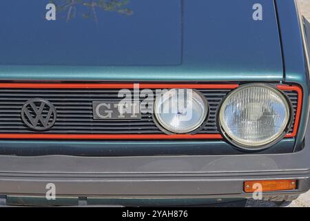 Primo piano della parte anteriore di un classico golf volkswagen gti, che mette in risalto l'iconico bordo rosso e il logo Foto Stock