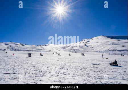 In inverno, in una giornata di sole, le persone corrono in discesa sul tubing. Shymkent, Kazakistan - 27 gennaio 2024 Foto Stock