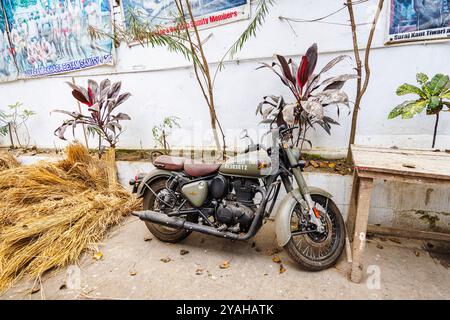 Una motocicletta d'epoca verde oliva Royal Enfield parcheggiata vicino al mercato dei fiori di Howrah in Strand Bank Road, Kolkata (Calcutta), Bengala Occidentale, India Foto Stock