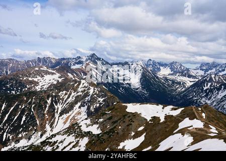Vista panoramica della catena montuosa innevata contro il cielo nuvoloso. I monti Tatra a Zakopane, Polonia. Cima del monte Giewont. Paesaggio naturale Foto Stock