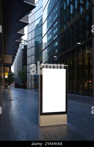 Cartellone digitale vuoto in un passaggio pedonale tra moderni edifici per uffici nel quartiere degli affari di Londra Foto Stock