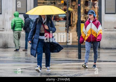 Londra, Regno Unito. 14 ottobre 2024. I primi acquirenti sono a Oxford Street nonostante la pioggia battente - il clima autunnale bagnato continua a colpire Londra. Anorak, felpe con cappuccio, ombrelli, poncho, sono all'ordine del giorno. Crediti: Guy Bell/Alamy Live News Foto Stock