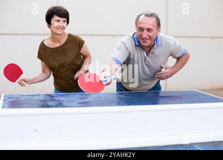 Felice matura spousesn giocare a ping pong Foto Stock