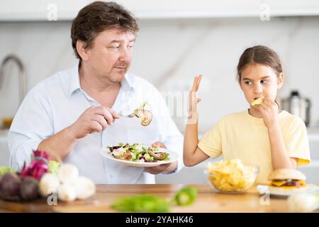 La figlia si rifiuta di mangiare cibo preparato dal padre Foto Stock