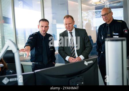 Amburgo, Germania. 14 ottobre 2024. Andy Grote (SPD, M), senatore per gli interni e lo sport ad Amburgo, visita il centro modernizzato di controllo del traffico presso la sede della polizia con Enno Treumann (r), capo della direzione della polizia di Amburgo, e Jan Krolzig (l), capo del centro di controllo del traffico. Crediti: Jonas Walzberg/dpa/Alamy Live News Foto Stock