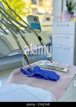 Gli utensili dentali sono disposti in modo ordinato in una clinica moderna con guanti e materiali visibili Foto Stock