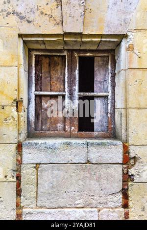 Finestre rotte bloccate nel muro di pietra di un vecchio edificio - le Petit-Pressigny, Indre-et-Loire (37), Francia. Foto Stock