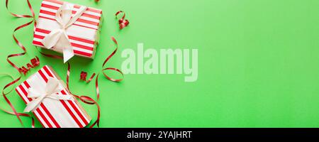 Appartamento vacanza con scatole regalo avvolte in carta colorata e legato decorato con confetti su sfondo colorato. Natale, compleanno, San Valentino e. Foto Stock