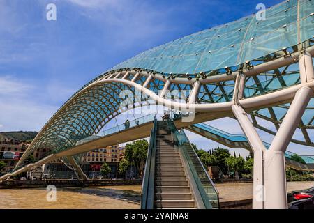vista obliqua delle scale che conducono all'iconico ponte di pace che attraversa il fiume kura a tbilisi, georgia Foto Stock