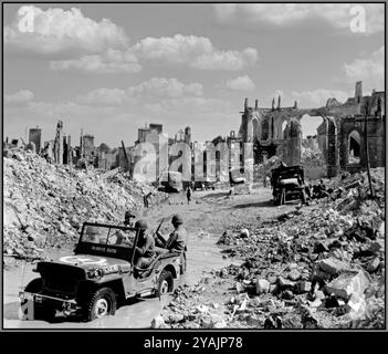 BATTAGLIA DI NORMANDIA dopo il D-Day. Valognes Normandia in rovina, 24 giugno 1944 Una jeep soprannominata "Always Ruth" dal 298° ingegnere combattente della 1a Armata degli Stati Uniti in primo piano. Place Vicq d'Azir e la chiesa collegiata di Saint-Malo, il cui campanile è stato fatto esplodere dagli ingegneri americani perché rischiava di crollare. Sullo sfondo, camion e un escavatore meccanico ripuliscono le macerie per il movimento dei convogli militari verso Cherbourg in Francia Foto Stock