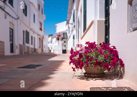 Vicolo tradizionale nella cittadina spagnola in una soleggiata giornata estiva con un cielo azzurro. Esempio di architettura classica di un villaggio in Spagna a Minorca Foto Stock