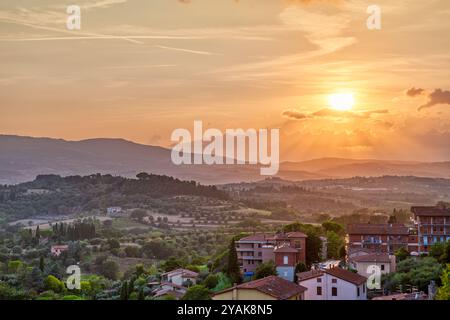 Tramonto in Toscana, piccolo paese di chiusi, Italia con tetti di case sulla campagna di montagna, dolci colline paesaggio idilliaco Foto Stock