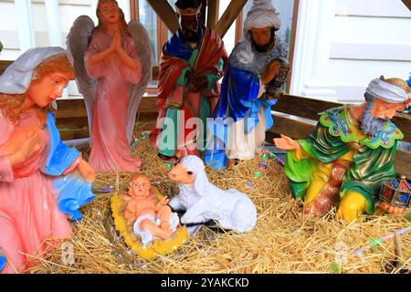 Natività di Gesù Cristo, presepe vicino alla chiesa. Vergine Maria, San Giuseppe, Gesù bambino, angeli e animali. Decorazione di Natale e Capodanno Foto Stock