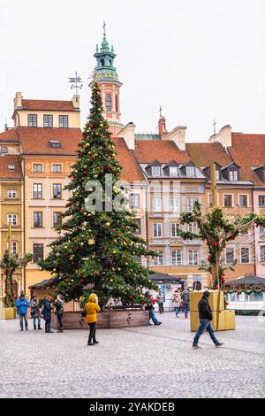 Varsavia, Polonia - 25 dicembre 2019: Albero di Natale nella piazza del mercato della città vecchia di Warszawa a Capodanno decorato con ornamenti con persone che camminano Foto Stock