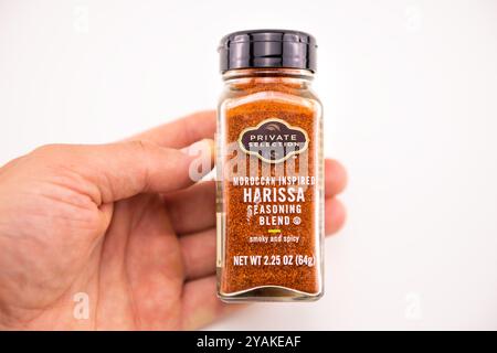 Avon, Stati Uniti - 4 agosto 2022: Peperoncino piccante macinato con condimento Harissa, condimento tradizionale marocchino, tenuta a mano su tavola su sfondo bianco Foto Stock