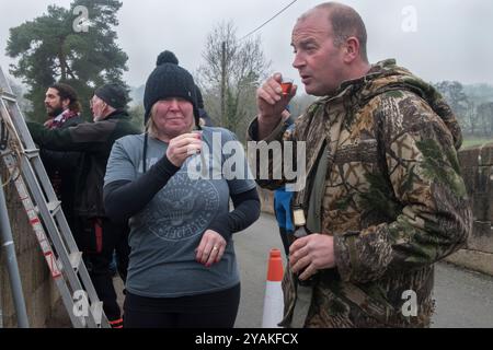 Bevendo un po' di rum, i jumpers festeggiano il nuovo anno partecipando al ponte Okeover Jump. Tuffati nel fiume dove. La mattina di Capodanno. Mappleton Derbyshire Inghilterra anni 2020 2020 UK HOMER SYKES Foto Stock