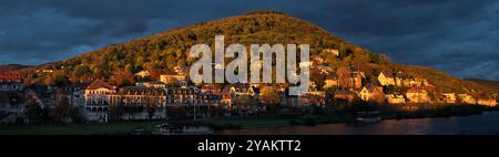 Scenografica area residenziale su una collina di Heidelberg, Germania, illuminata dalla calda e intensa luce del tramonto, con nuvole scure Foto Stock