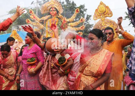 Kolkata, India. 13 ottobre 2024. Donne che ballano con Dhunachi durante la processione di immersione dell'idolo della dea Durga, che segna l'ultimo giorno delle celebrazioni del Durga Puja Festival. Il 13 ottobre 2024 a Kolkata, India. (Foto di Dipa Chakraborty/ credito: Eyepix Group/Alamy Live News Foto Stock