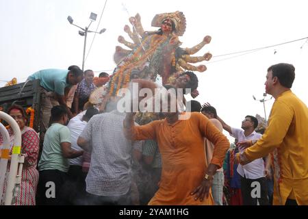 Kolkata, India. 13 ottobre 2024. I devoti si preparano ad immergere un idolo della dea indù Durga durante la cerimonia di immersione di Durga Puja, che segna l'ultimo giorno delle celebrazioni del Durga Puja Festival. Il 13 ottobre 2024 a Kolkata, India. (Foto di Dipa Chakraborty/ credito: Eyepix Group/Alamy Live News Foto Stock