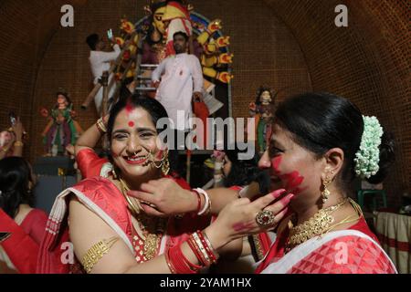 Kolkata, India. 13 ottobre 2024. Le donne che prendono parte alla polvere Sindoor Khela o vermillion, l'una sull'altra dopo aver adorato un idolo della dea indù Durga che segna l'ultimo giorno delle celebrazioni del Durga Puja Festival. Il 13 ottobre 2024 a Kolkata, India. (Foto di Dipa Chakraborty/ credito: Eyepix Group/Alamy Live News Foto Stock