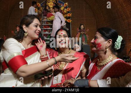 Kolkata, India. 13 ottobre 2024. Le donne che prendono parte alla polvere Sindoor Khela o vermillion, l'una sull'altra dopo aver adorato un idolo della dea indù Durga che segna l'ultimo giorno delle celebrazioni del Durga Puja Festival. Il 13 ottobre 2024 a Kolkata, India. (Foto di Dipa Chakraborty/ credito: Eyepix Group/Alamy Live News Foto Stock