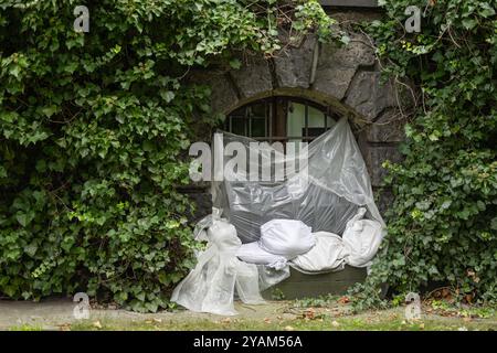 Coperture protettive in plastica e sacchetti di sabbia che proteggono la finestra di un edificio storico contro i danni causati dalle inondazioni Foto Stock