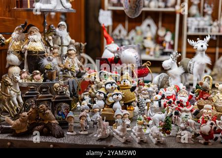 Statuette e decorazioni natalizie in mostra al mercato natalizio. Concetto di ornamenti stagionali tradizionali e festività invernali Foto Stock