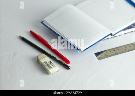 Indonesia 9 settembre 2024, quaderno con altra cancelleria in foto ravvicinata da un angolo laterale su sfondo bianco isolato Foto Stock