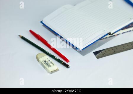 Indonesia 9 settembre 2024, quaderno con altra cancelleria in foto ravvicinata da un angolo laterale su sfondo bianco isolato Foto Stock