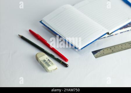 Indonesia 9 settembre 2024, quaderno con altra cancelleria in foto ravvicinata da un angolo laterale su sfondo bianco isolato Foto Stock