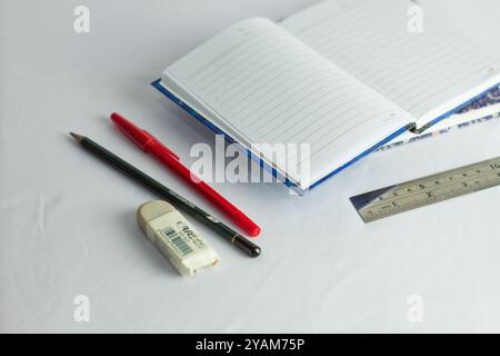Indonesia 9 settembre 2024, quaderno con altra cancelleria in foto ravvicinata da un angolo laterale su sfondo bianco isolato Foto Stock