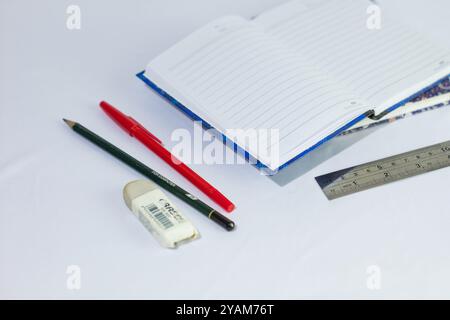 Indonesia 9 settembre 2024, quaderno con altra cancelleria in foto ravvicinata da un angolo laterale su sfondo bianco isolato Foto Stock