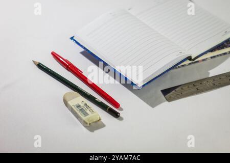 Indonesia 9 settembre 2024, quaderno con altra cancelleria in foto ravvicinata da un angolo laterale su sfondo bianco isolato Foto Stock