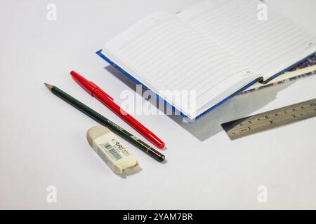 Indonesia 9 settembre 2024, quaderno con altra cancelleria in foto ravvicinata da un angolo laterale su sfondo bianco isolato Foto Stock