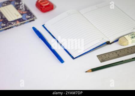 Indonesia 9 settembre 2024, quaderno con altra cancelleria in foto ravvicinata da un angolo laterale su sfondo bianco isolato Foto Stock