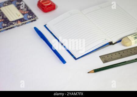 Indonesia 9 settembre 2024, quaderno con altra cancelleria in foto ravvicinata da un angolo laterale su sfondo bianco isolato Foto Stock