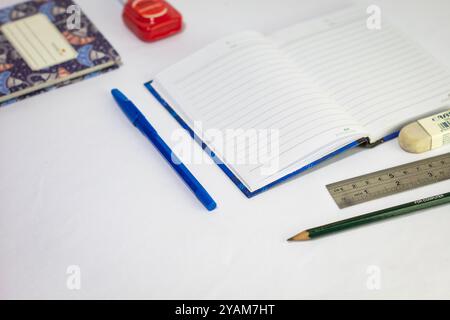 Indonesia 9 settembre 2024, quaderno con altra cancelleria in foto ravvicinata da un angolo laterale su sfondo bianco isolato Foto Stock