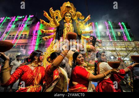 Kolkata, India. 14 ottobre 2024. Le donne indù dedite eseguono dhunuchi in occasione dell'immersione in Durga Puja. Durga Puja, un festival annuale che segna la vittoria del bene sul male, è celebrato dagli indù in tutta l'India e all'estero. E' un'occasione di grande entusiasmo e di festa per gli indù. L'ultimo giorno, il giorno di Bhashan o Vijoya Dashami immagini e idoli sono immersi nell'acqua. Credito: SOPA Images Limited/Alamy Live News Foto Stock