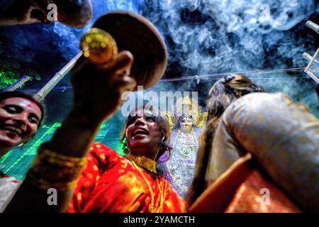 Kolkata, India. 14 ottobre 2024. Le donne indù dedite eseguono dhunuchi con abiti bengalesi tradizionali in occasione dell'immersione Durga Puja. Durga Puja, un festival annuale che segna la vittoria del bene sul male, è celebrato dagli indù in tutta l'India e all'estero. E' un'occasione di grande entusiasmo e di festa per gli indù. L'ultimo giorno, il giorno di Bhashan o Vijoya Dashami immagini e idoli sono immersi nell'acqua. Credito: SOPA Images Limited/Alamy Live News Foto Stock