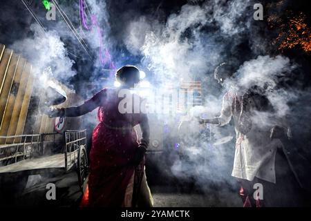 Kolkata, India. 14 ottobre 2024. Le donne indù dedite eseguono dhunuchi in occasione dell'immersione in Durga Puja. Durga Puja, un festival annuale che segna la vittoria del bene sul male, è celebrato dagli indù in tutta l'India e all'estero. E' un'occasione di grande entusiasmo e di festa per gli indù. L'ultimo giorno, il giorno di Bhashan o Vijoya Dashami immagini e idoli sono immersi nell'acqua. Credito: SOPA Images Limited/Alamy Live News Foto Stock