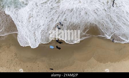 I nuotatori scivolano attraverso le onde cristalline al largo della costa californiana, sotto un sole dorato in una perfetta giornata estiva, dipingendo un ambiente acquatico sereno Foto Stock