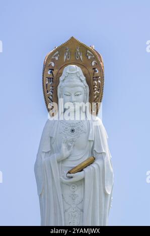 Vista della statua della dea Guanyin sul territorio del centro buddista Nanshan in giornata di sole Foto Stock